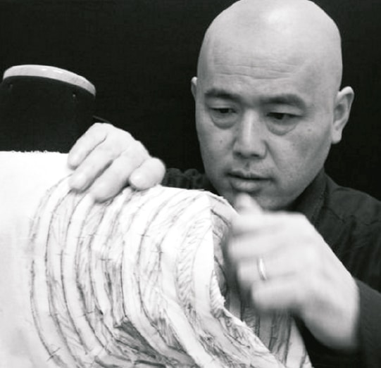 Master Shingo Sato draping and cutting directly on a mannequin
